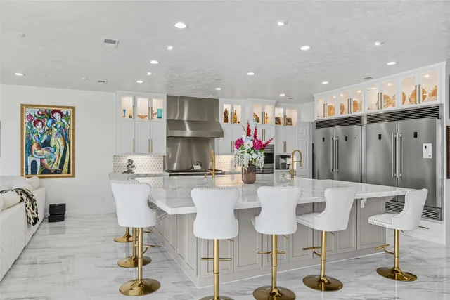 a kitchen with stainless steel appliances kitchen island granite countertop a table and chairs in it