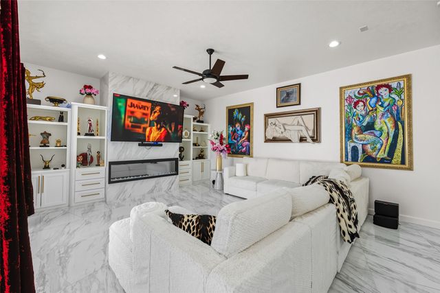 a kitchen with stainless steel appliances kitchen island granite countertop a dining table chairs and a refrigerator