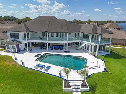an aerial view of a house with swimming pool and big yard