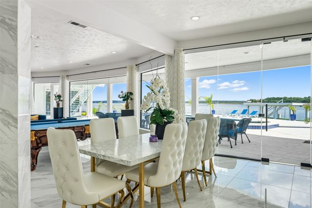 a view of a dining room with furniture large windows and wooden floor
