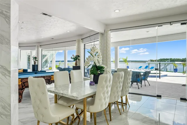 a view of a dining room with furniture large windows and wooden floor