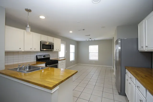 a kitchen with a sink white cabinets and appliances