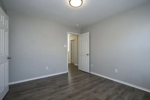 a view of an empty room and window and wooden floor