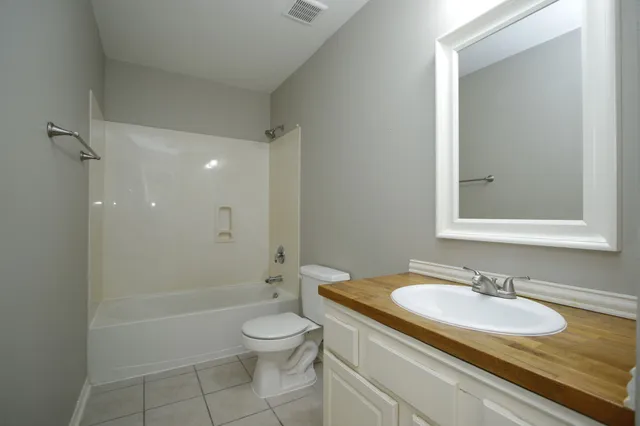 an empty room with wooden floor ceiling fan and windows