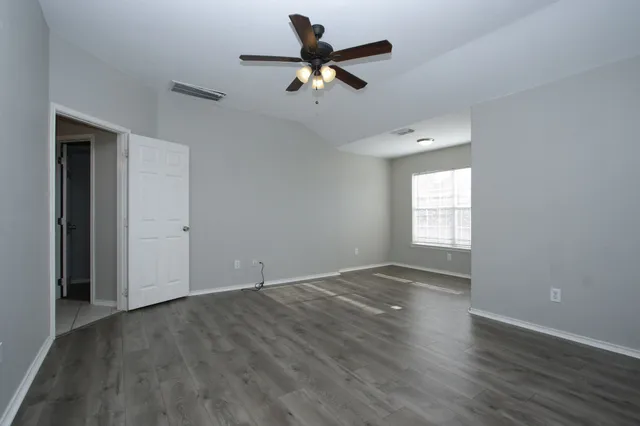 wooden floor in an empty room with a window