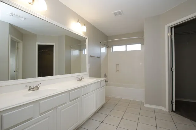 a spacious bathroom with a shower sink and mirror