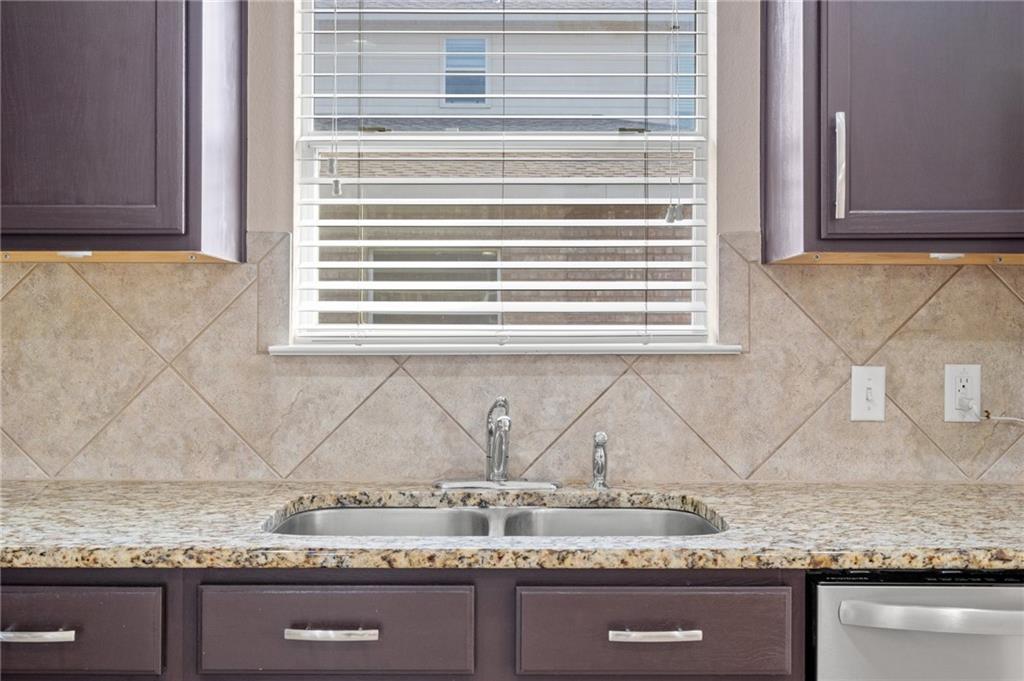 20224 Merlin Falcon Trail Pflugerville, TX 78660 - Photo 17 of 40 A well-appointed kitchen features a double basin sink set in granite, framed by cabinetry.
