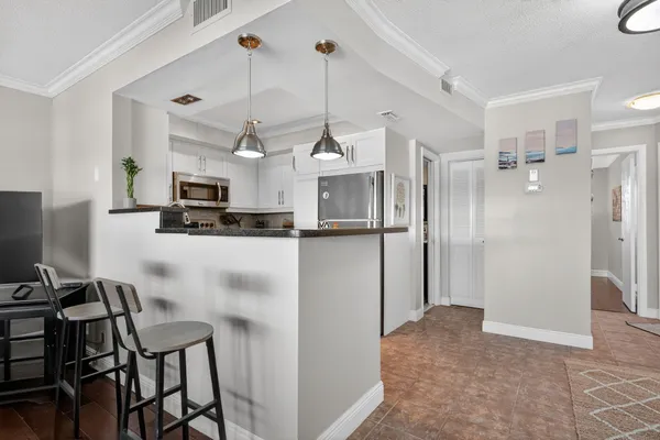 a view of a kitchen with kitchen island dining table and stainless steel appliances