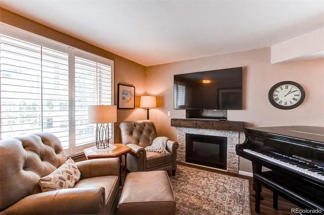 a living room with furniture a large window and a fireplace