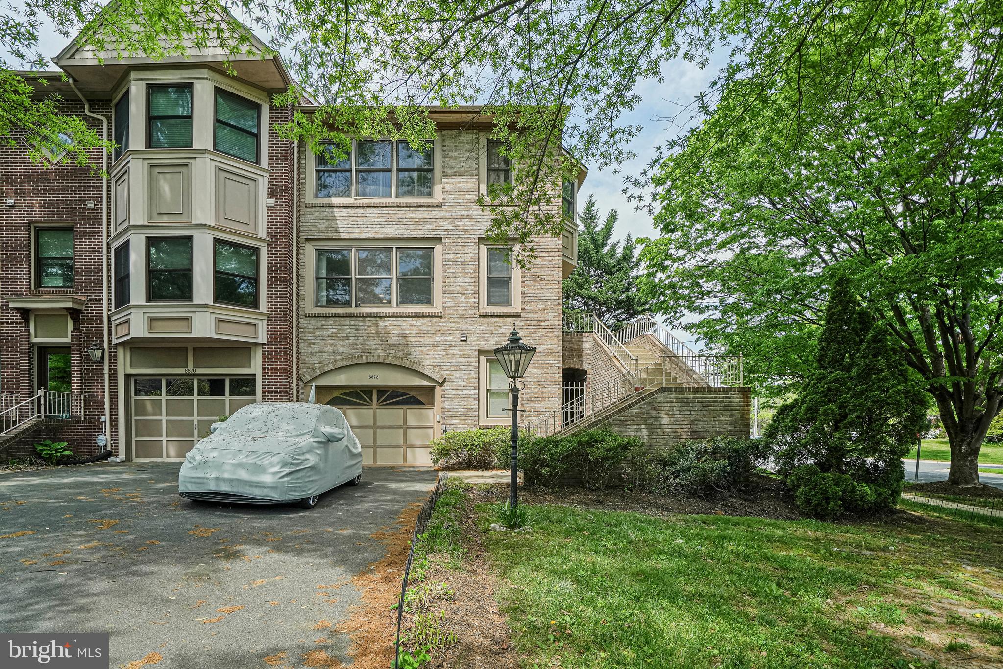 a front view of a house with a garden and trees