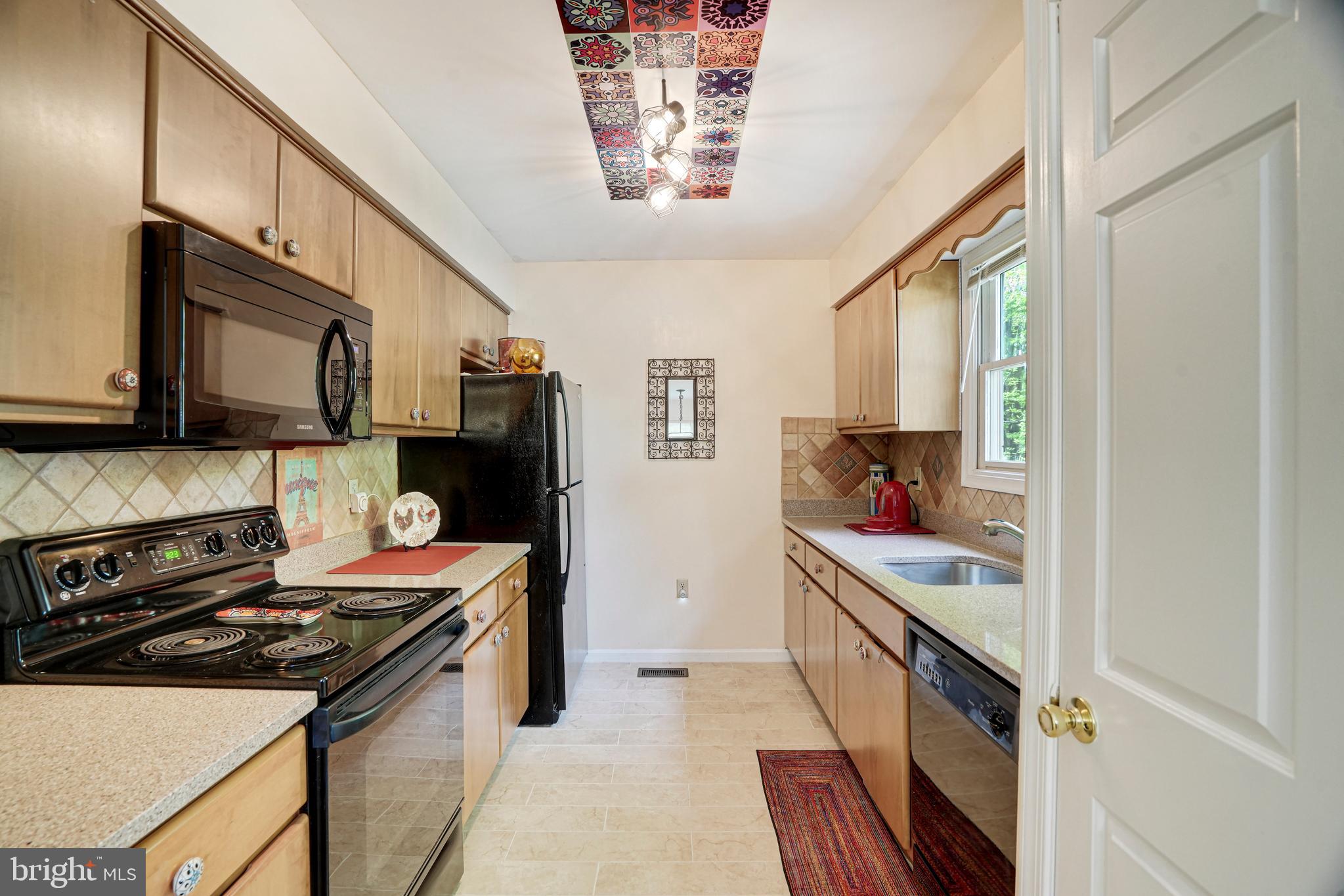 8872 Woodland Drive Silver Spring, MD 20910 - Photo 11 of 47 a kitchen with stainless steel appliances a stove refrigerator sink and microwave