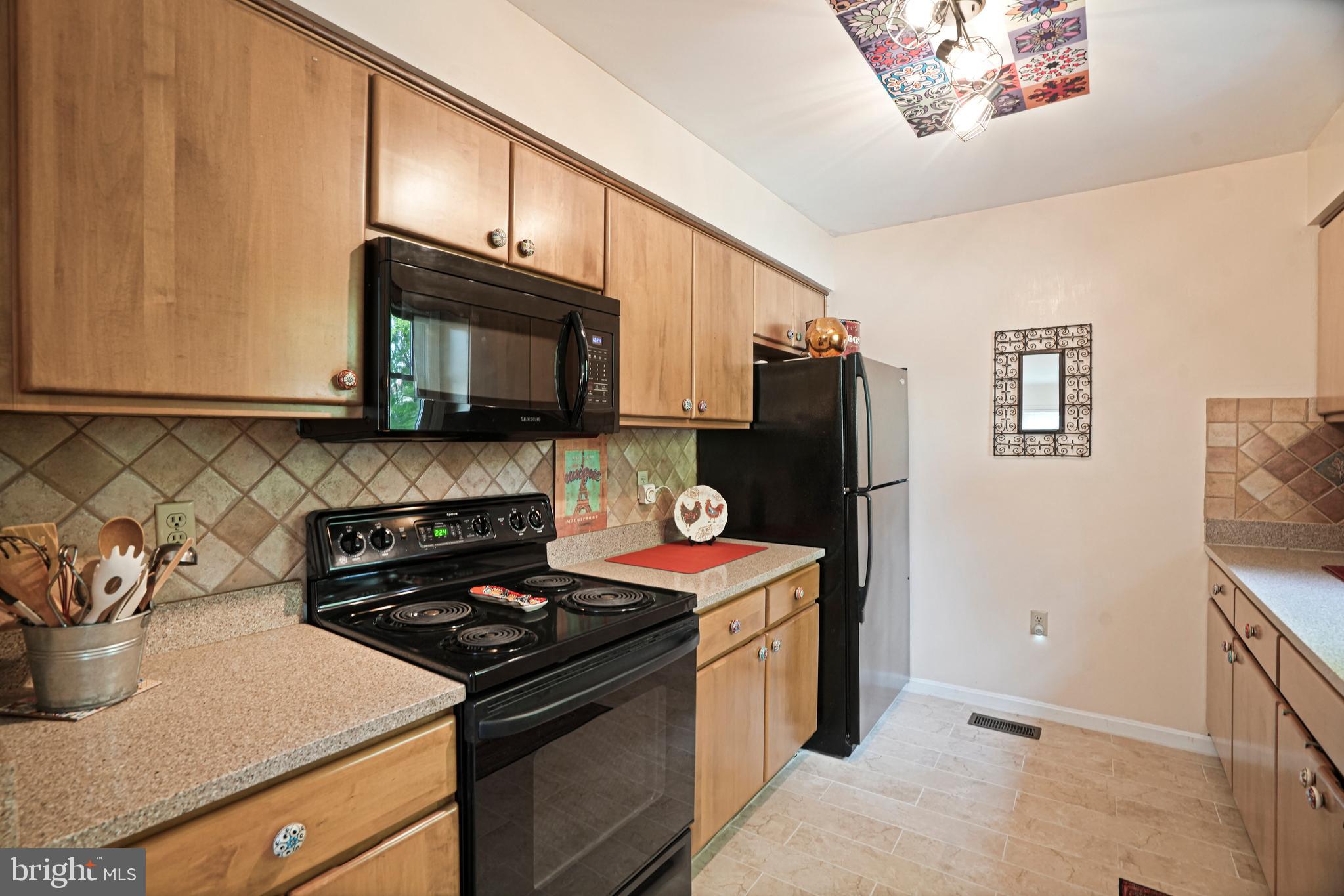 8872 Woodland Drive Silver Spring, MD 20910 - Photo 9 of 47 a kitchen with stainless steel appliances granite countertop a stove a sink and a microwave