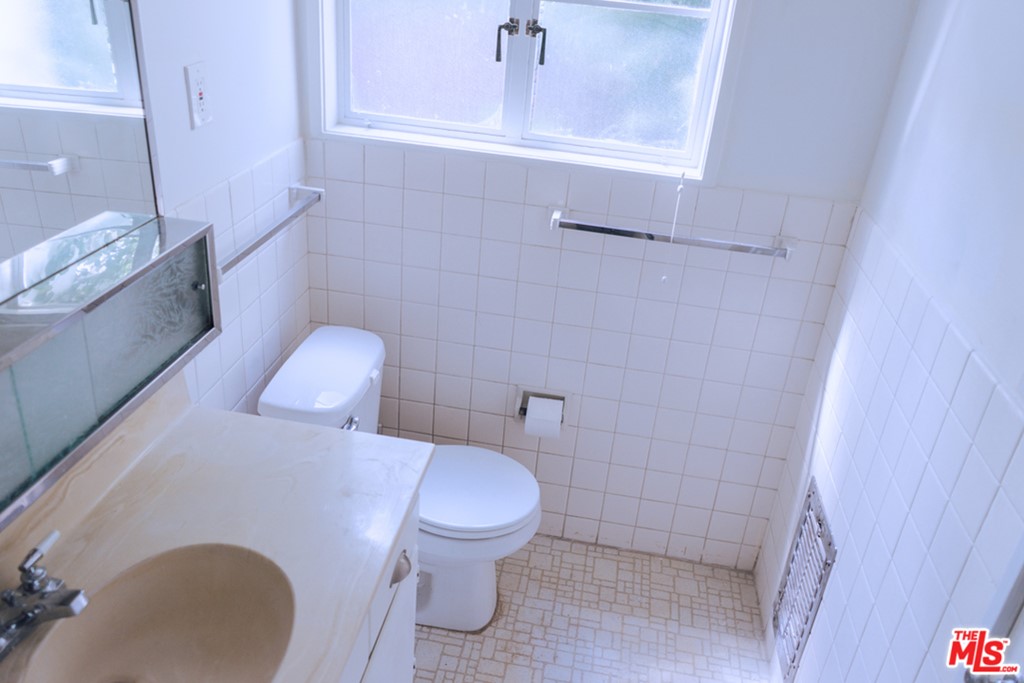 5478 Village Los Angeles, CA 90016 - Photo 25 of 31 a white toilet sitting next to a bathroom sink and vanity