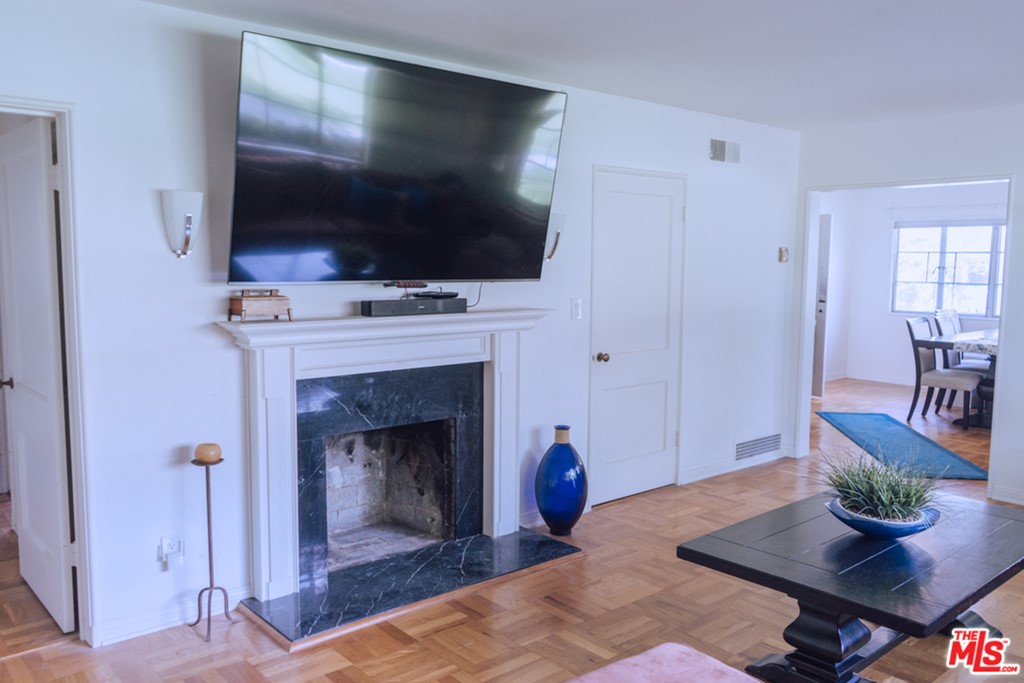 5478 Village Los Angeles, CA 90016 - Photo 5 of 31 a living room with furniture a flat screen tv and a fireplace