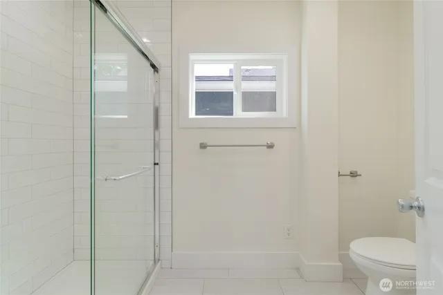 a bathroom with a granite countertop window a toilet and a shower