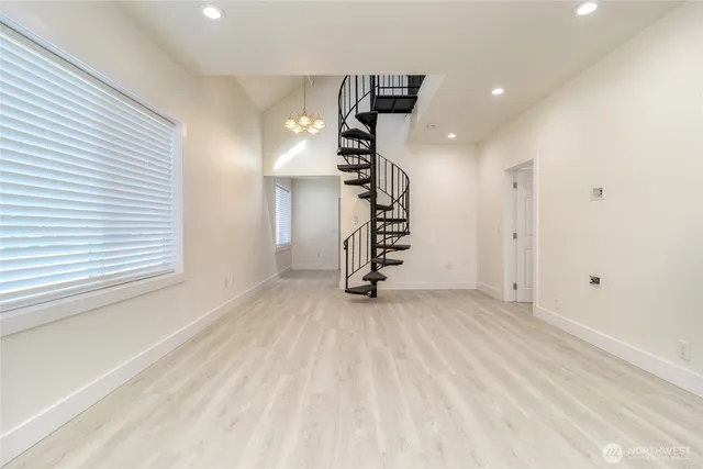 an empty room with windows and stairs