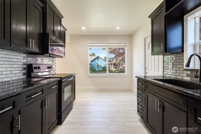 a kitchen with stainless steel appliances granite countertop a sink stove and oven