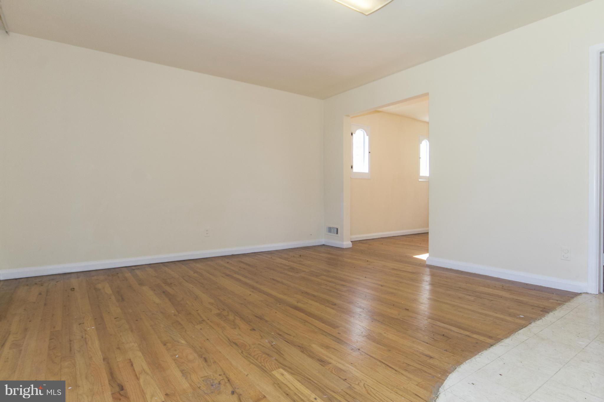 7105 Boxford Road Baltimore, MD 21215 - Photo 4 of 27 an empty room with wooden floor and windows