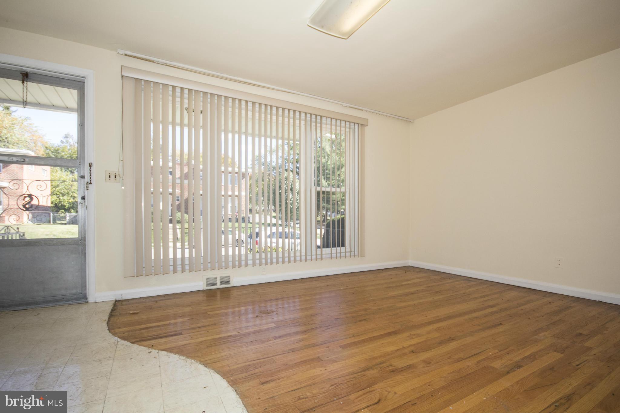 7105 Boxford Road Baltimore, MD 21215 - Photo 7 of 27 a view of an empty room with wooden floor and a window