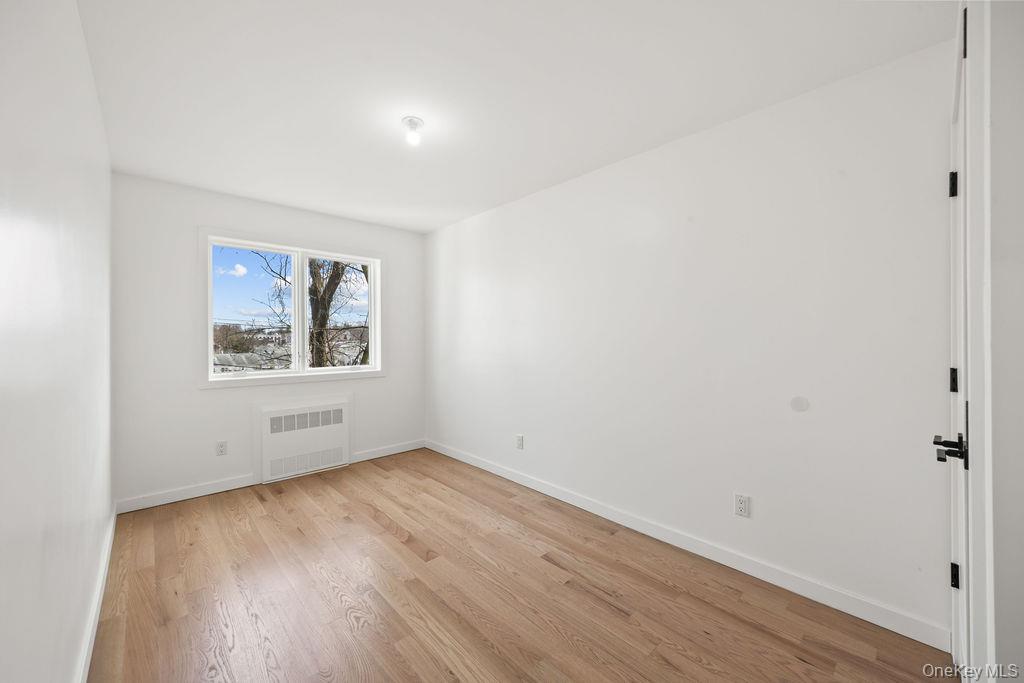 62 Blauvelt Road, Unit 202 Monsey, NY 10952 - Photo 31 of 34 an empty room with wooden floor and windows
