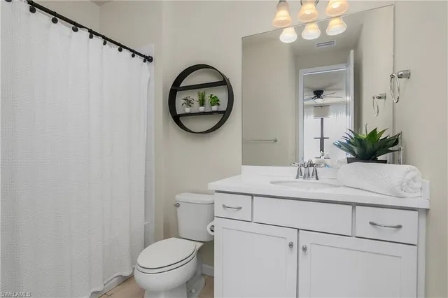a bathroom with a toilet sink vanity and mirror