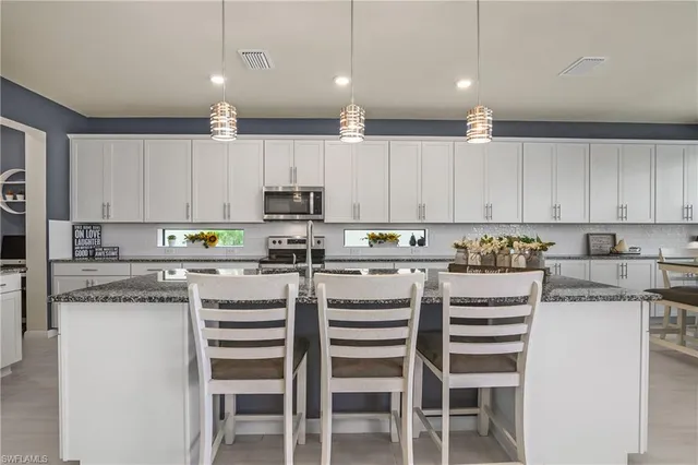 a kitchen with a white cabinets and chairs