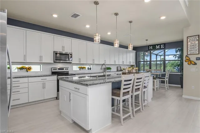 a kitchen with a white cabinets and chairs in it