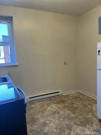 a view of empty room with wooden floor and fireplace