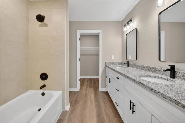 a bathroom with a tub sink and mirror