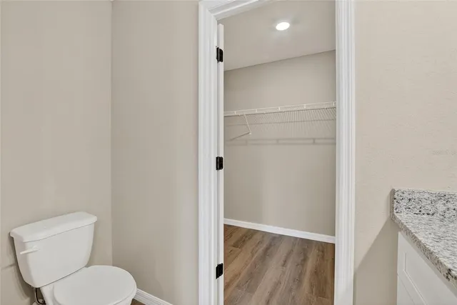 a bathroom with a granite countertop toilet and a sink