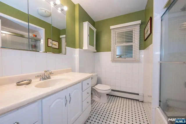 a bathroom with a sink a toilet a mirror and shower