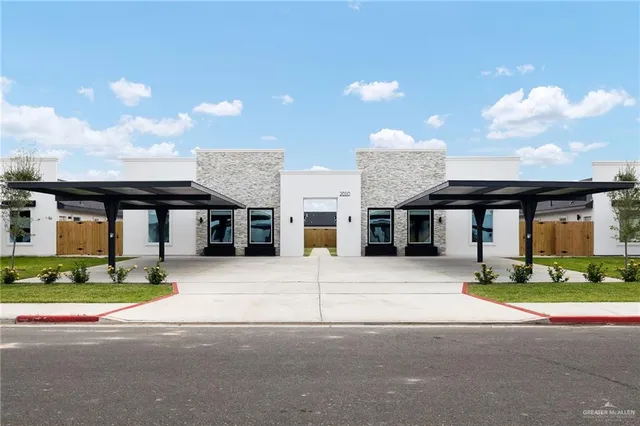 a front view of a house with garden and parking