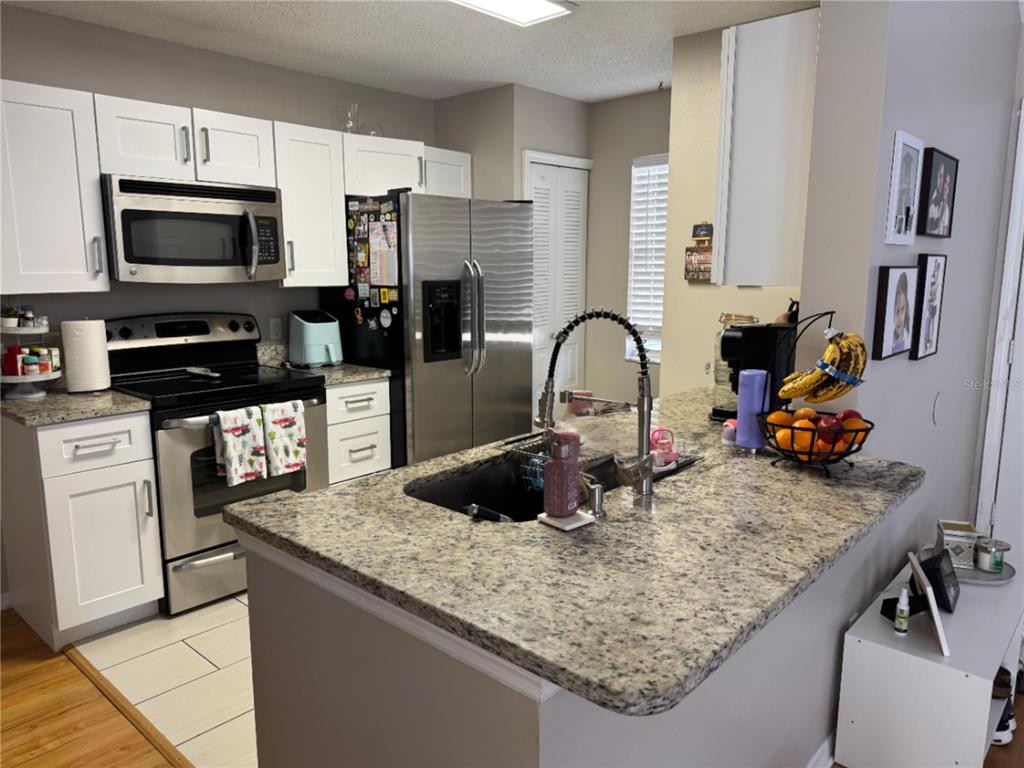 655 Magic Court, Unit 188 Altamonte Springs, FL 32714 - Photo 20 of 33 a kitchen with sink a microwave and cabinets