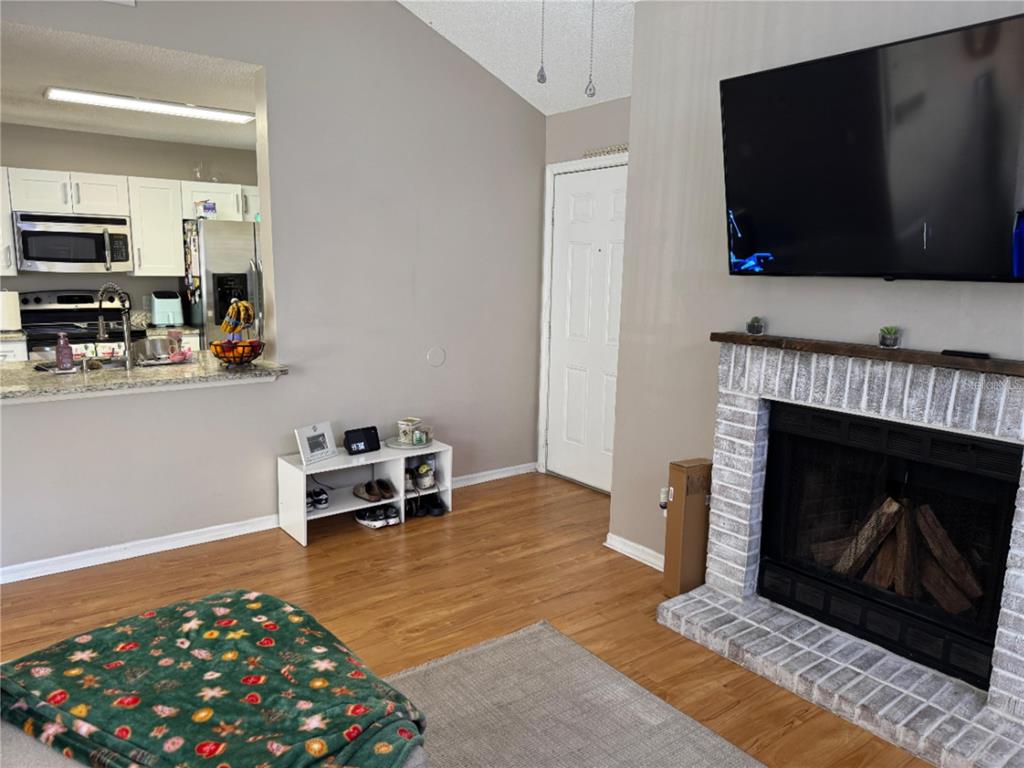 655 Magic Court, Unit 188 Altamonte Springs, FL 32714 - Photo 25 of 33 a living room with furniture a flat screen tv and a fireplace