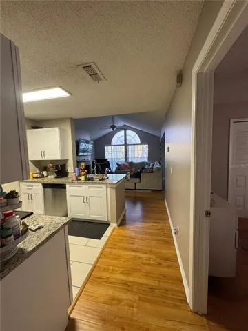a bedroom with a bed mirror on dresser and a flat screen tv