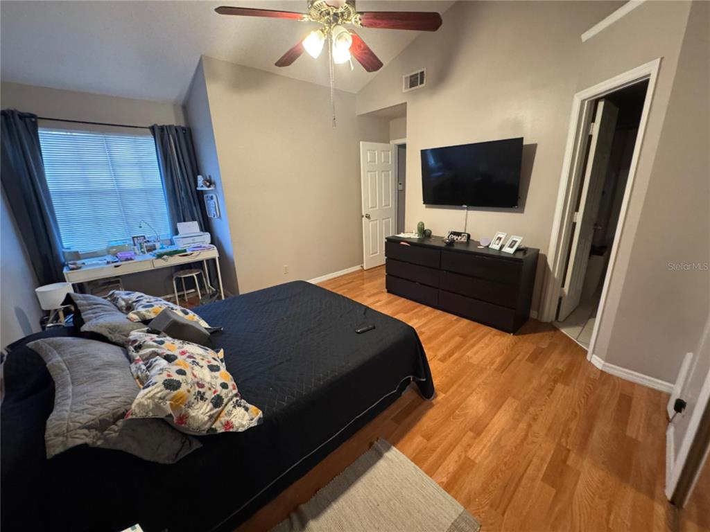 655 Magic Court, Unit 188 Altamonte Springs, FL 32714 - Photo 30 of 33 a bedroom with a bed mirror on dresser and a flat screen tv