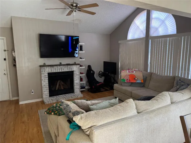 a living room with furniture a flat screen tv and a fireplace