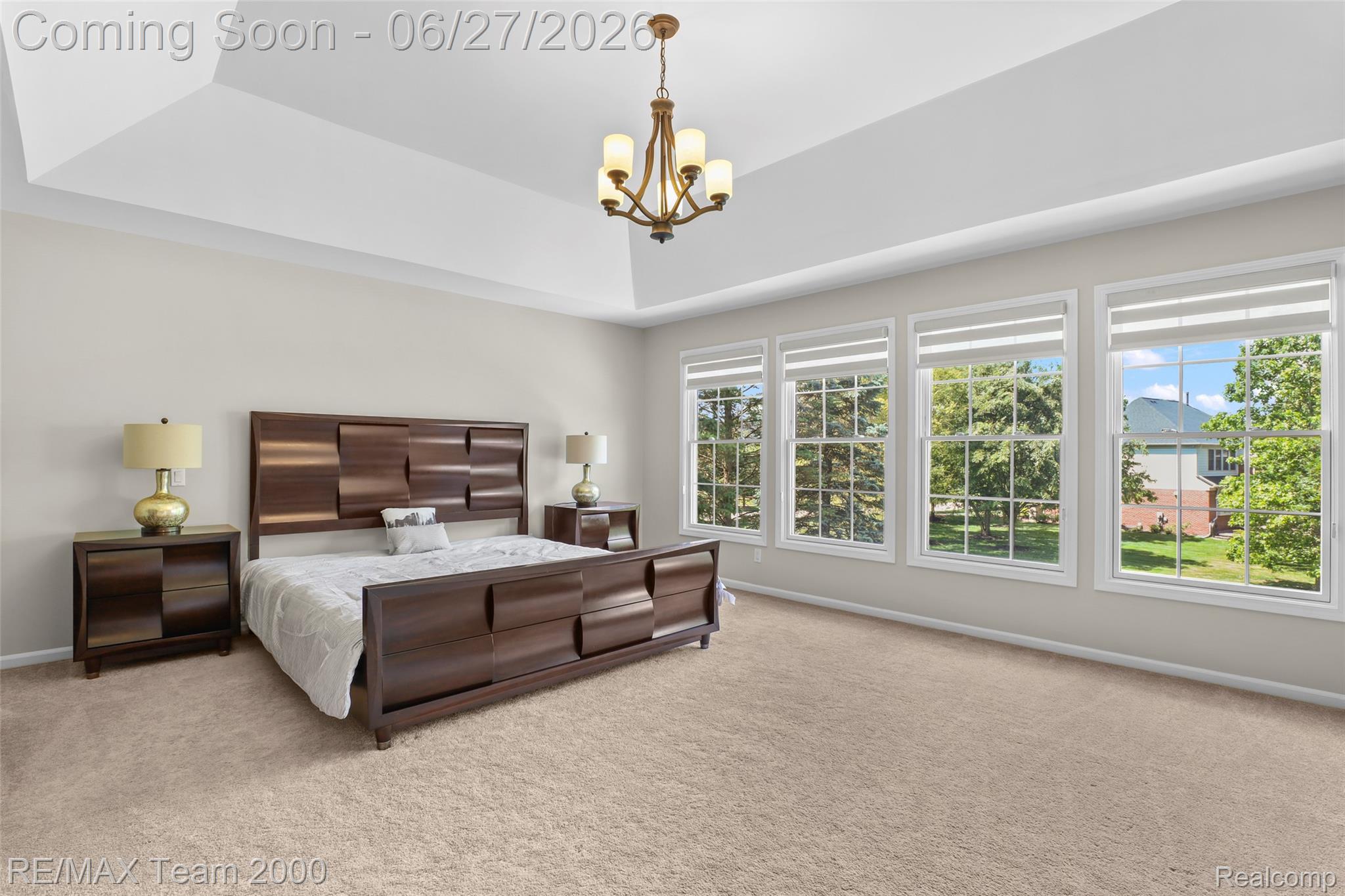 1248 Lasalle Road Canton, MI 48187 - Photo 52 of 67 Spacious bedroom featuring a tray ceiling with a central chandelier, light-toned carpeting, and a wall of four large windows