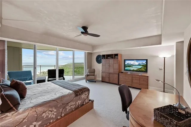 a spacious bedroom with a bed a couch and large window