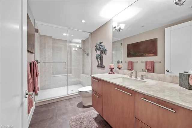 a bathroom with a granite countertop sink toilet and shower