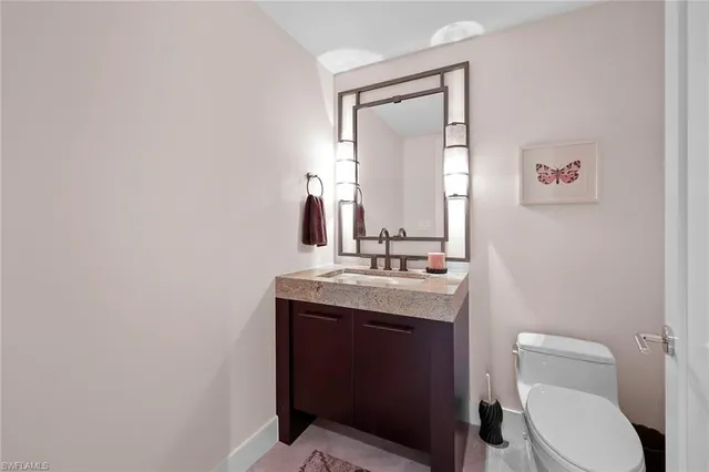 a bathroom with a toilet a sink and mirror