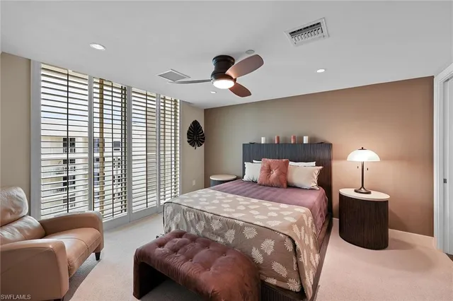 a bedroom with furniture and a large window