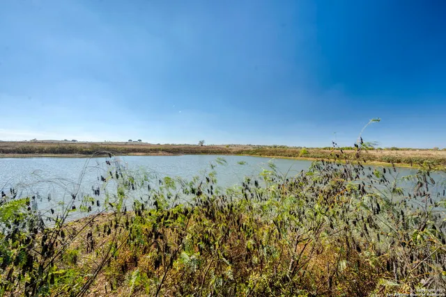 an aerial view of a house with a lake