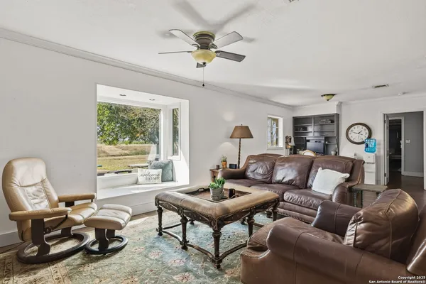 a living room with furniture a table and a large window