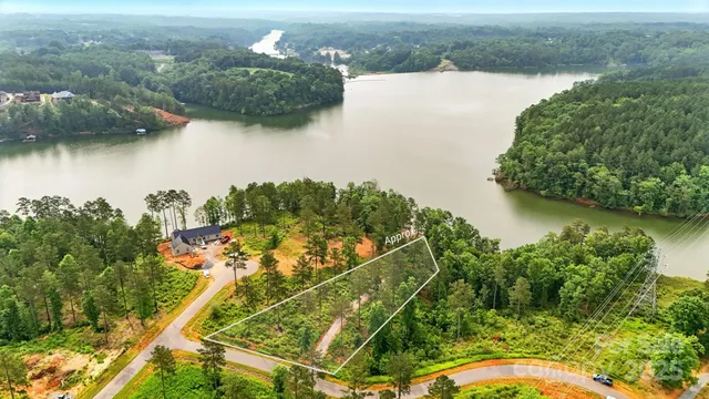 an aerial view of a house with a yard and lake view