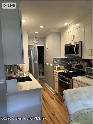 a kitchen with stainless steel appliances kitchen island granite countertop a refrigerator stove and oven