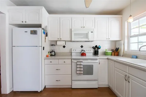 a kitchen with cabinets appliances a sink and a window