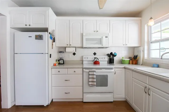 a kitchen with cabinets appliances a sink and a window