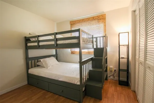 a bedroom with a bed and wooden floor