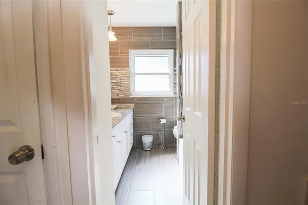 a bathroom with a granite countertop toilet and a shower